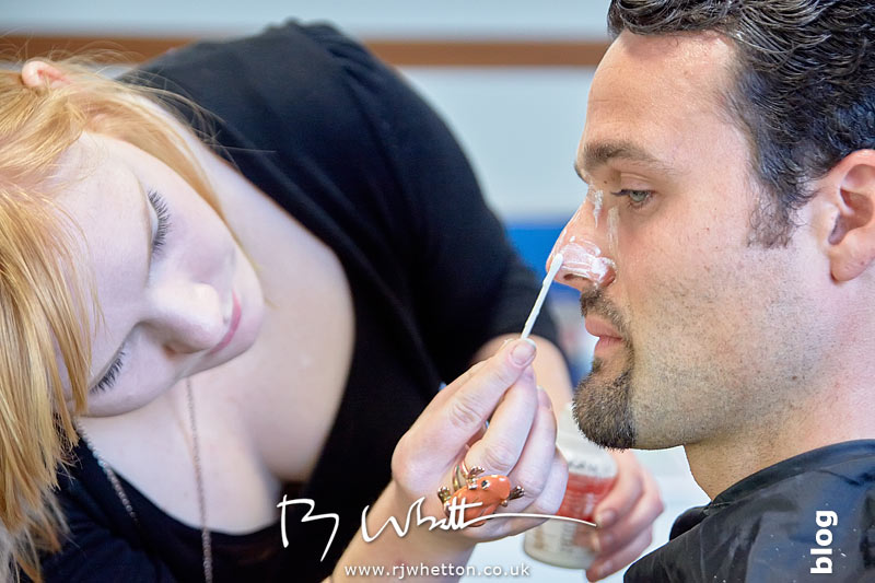 Make-up artist Sarah applies glue to Denzil's nose to stick the prosthetic in place Yes Sir Boss - Not Guilty Production Still - Production Photography Dorset