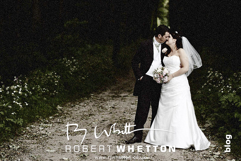 Wedding of Jo and Ben Christie at Kingston Country Courtyard, Swanage Jo and Ben kissing under the trees - Dorset Wedding Photographer Robert Whetton