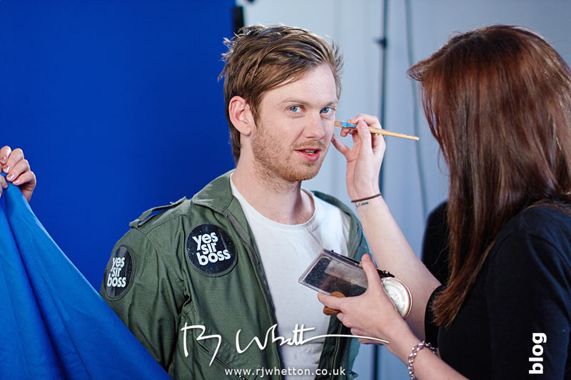 Lauren gives Matt a quick brush over with make-up before his take Yes Sir Boss - Not Guilty Production Still - Production Photography Dorset